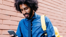 Man with backpack on mobile device