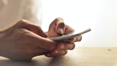 Hands search a mobile phone.