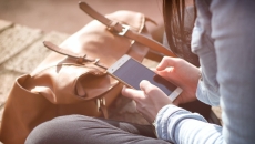 A person sitting on the floor holding their cellphone