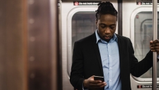 A person texting on a subway train