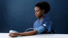 A clinician using a blood pressure monitor