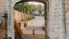 person standing in a city archway on stairs