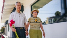 An elderly couple taking a walk while holding hands