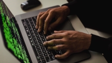 A person typing in codes in a laptop computer