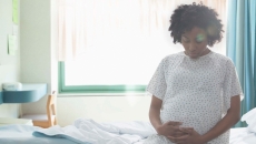 Pregnant person sitting on hospital bed