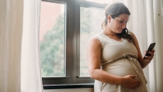 A pregnant person texting