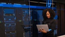 A software engineer standing near a server room