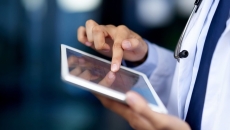A doctor holding a tablet.