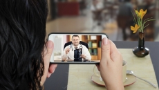 A patient looks at a doctor on a mobile phone screen