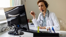 Doctor with headset talking to monitor