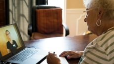 A patient speaks with a nurse via telehealth