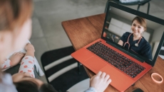 A doctor speaks to a parent and child via telemedicine