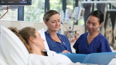 Nurses assisting a patient in bed