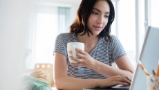 Person with coffee mug using computer