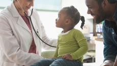 Doctor treating child with parent present