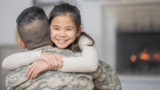 Servicemember hugs child