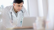 A doctor working on a laptop