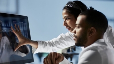 Scientists analysing data shown on a desktop computer
