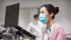 A nurse looking at a laptop dashboard of patient information