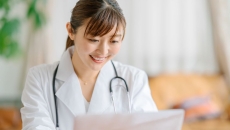 A smiling doctor studying a patient's brain images