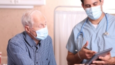 A doctor discussing a senior patient's results using a digital tablet
