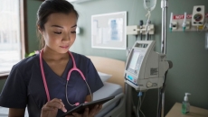 A doctor reviewing a patient's file on a digital tablet