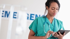 A nurse checking a patient file on a digital tablet