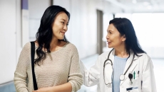 A doctor walking with a patient in a hospital corridor