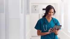 A doctor checking a patient record on their digital tablet.
