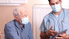 A doctor discussing to an elderly patient their test results using a tablet