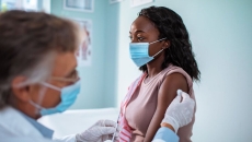 A woman wearing face mask getting vaccinated