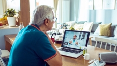 A senior person consulting with a doctor online on a laptop