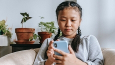 A person in braids browses on the phone