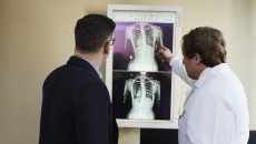 Two people look at an X ray of a ribcage