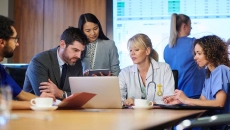 Healthcare workers meeting around a laptop