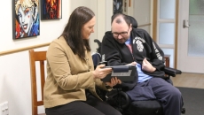 A Peninsula Health staff assisting a patient in inputting their care needs and preferences