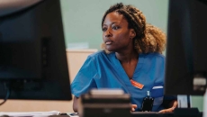 Healthcare worker using a computer with dual monitors