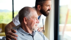 Caregiver and an elderly resident looking out a window