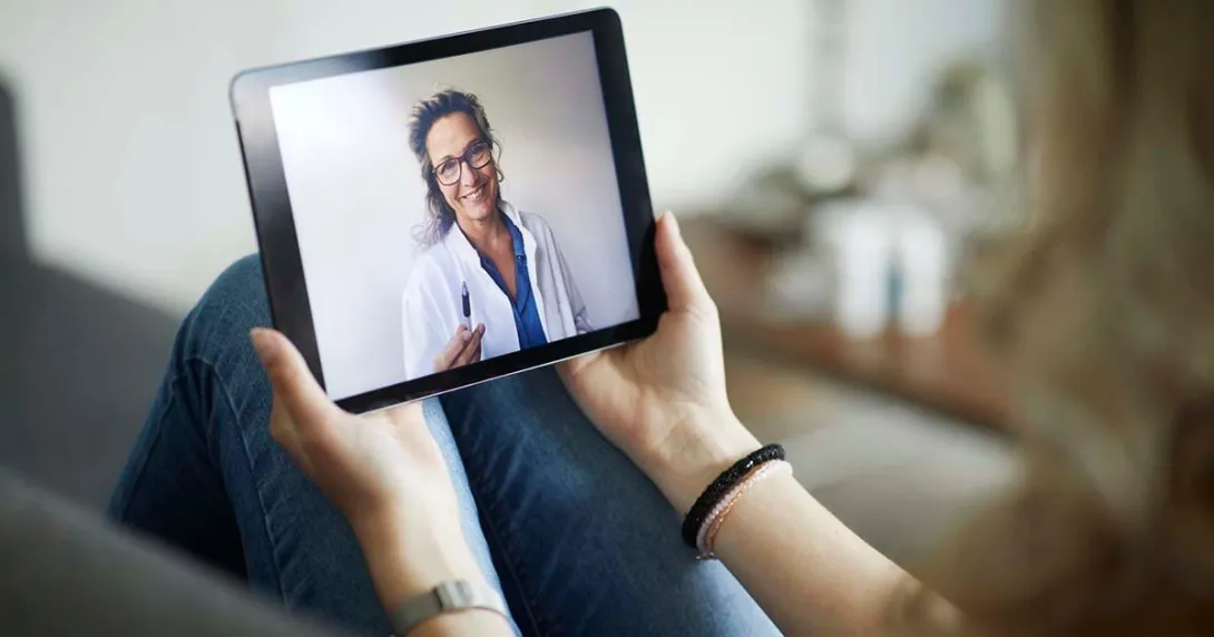 Female doctor on tablet for a telehealth visit