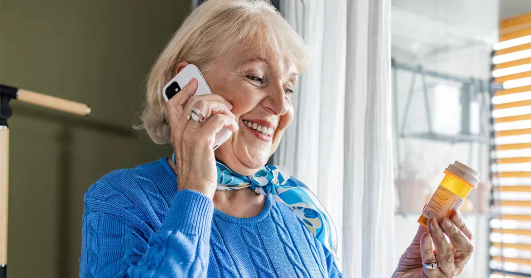 Person on phone holding pill bottle Person on phone holding pill bottle
