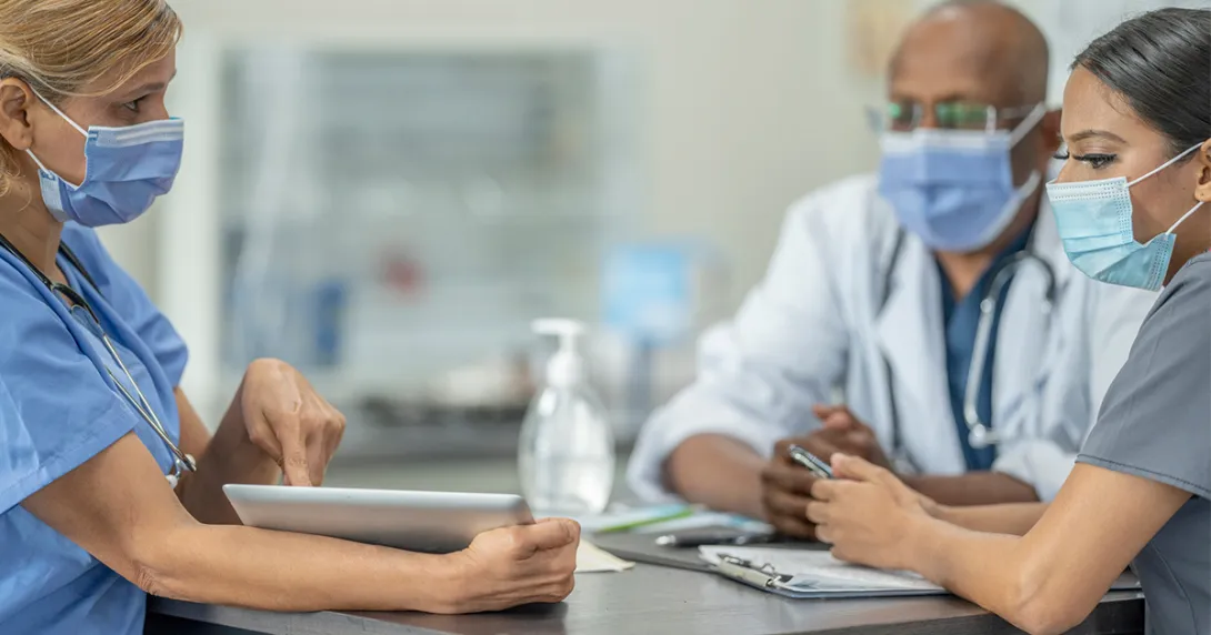 Healthcare worker showing tablet to others