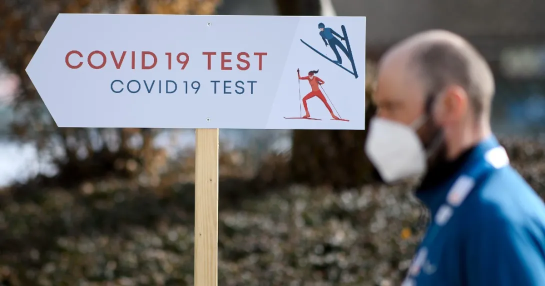 A person stands in front of a COVID-19 test sign
