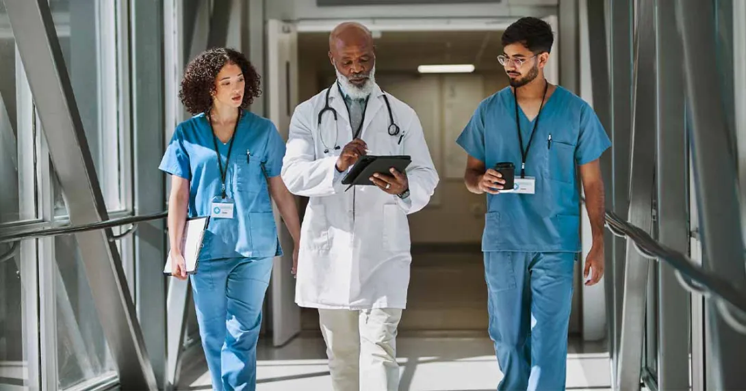 Healthcare workers walking with doctor in hospital hallway Healthcare workers walking with doctor in hospital hallway