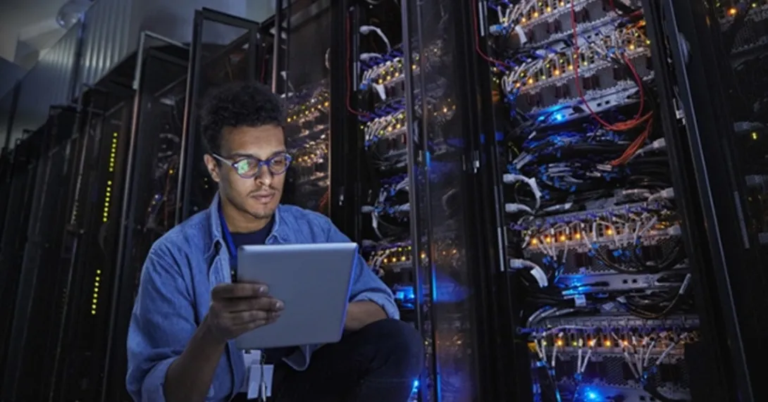 HIT computer engineer reviews security in a server room HIT computer engineer reviews security in a server room