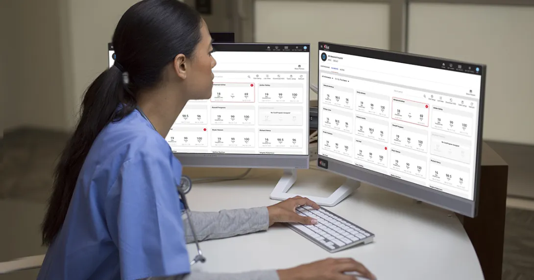 Healthcare worker working on a computer with dual monitors
