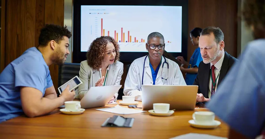 Medical professionals meeting with a graph in the background Medical professionals meeting with a graph in the background
