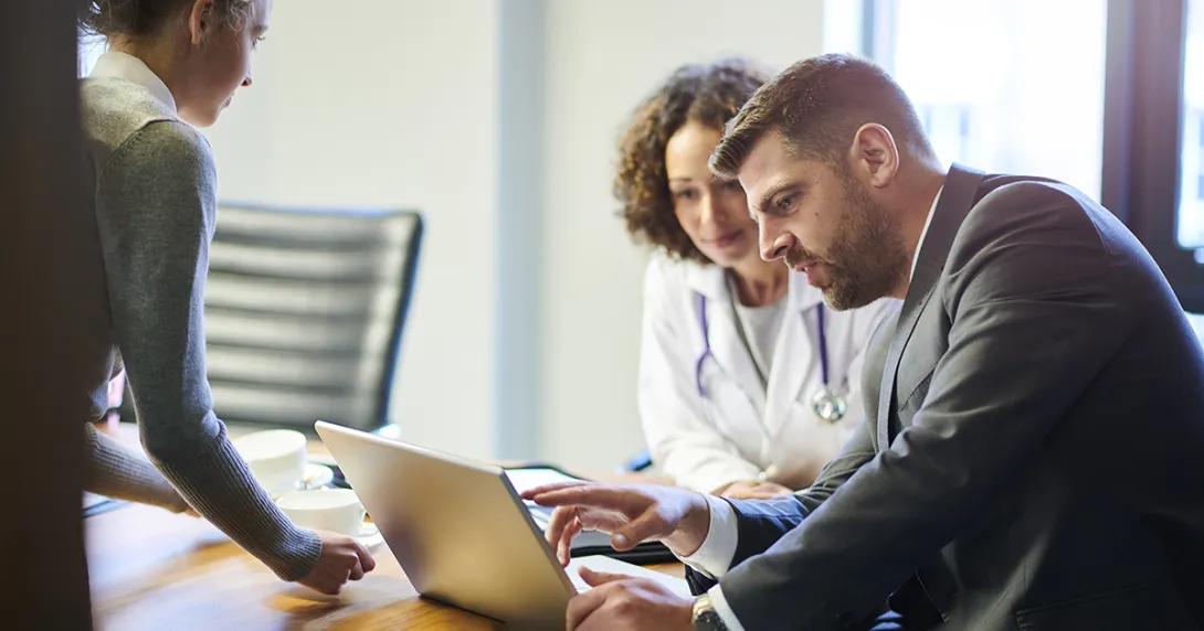 Doctor and businessperson looking at a laptop