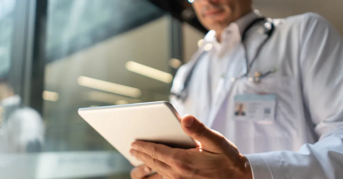 A doctor reviewing a patient's record on a digital tablet A doctor reviewing a patient's record on a digital tablet