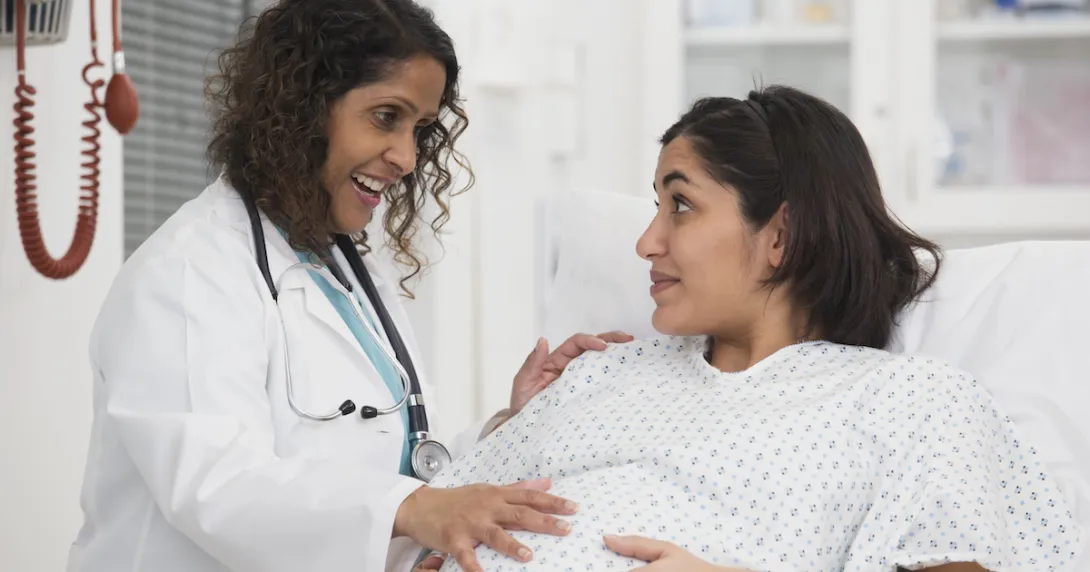 Doctor with hand on belly of pregnant patient Doctor with hand on belly of pregnant patient
