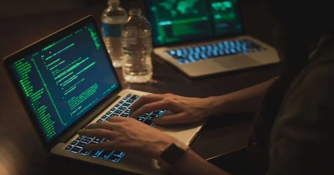 People in a darkened room at a computer